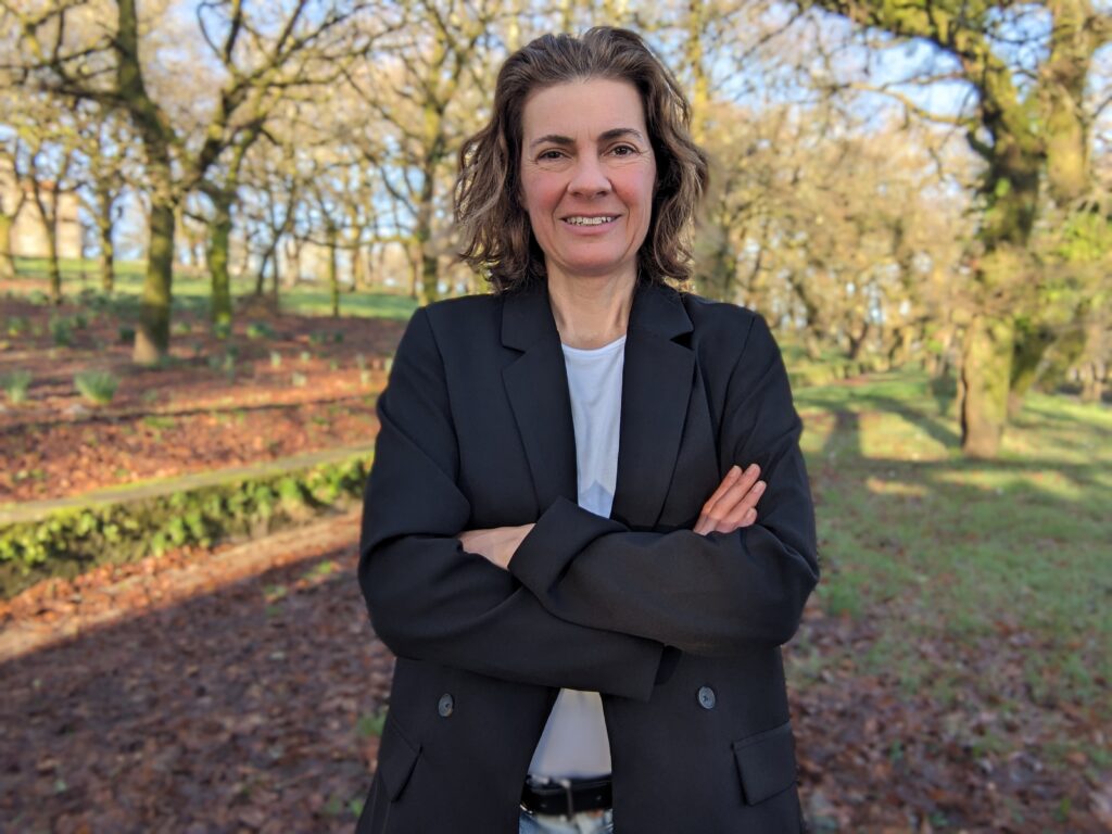 Heather McDaniel, Regenerative Leadership Expert, standing in a natural landscape. 